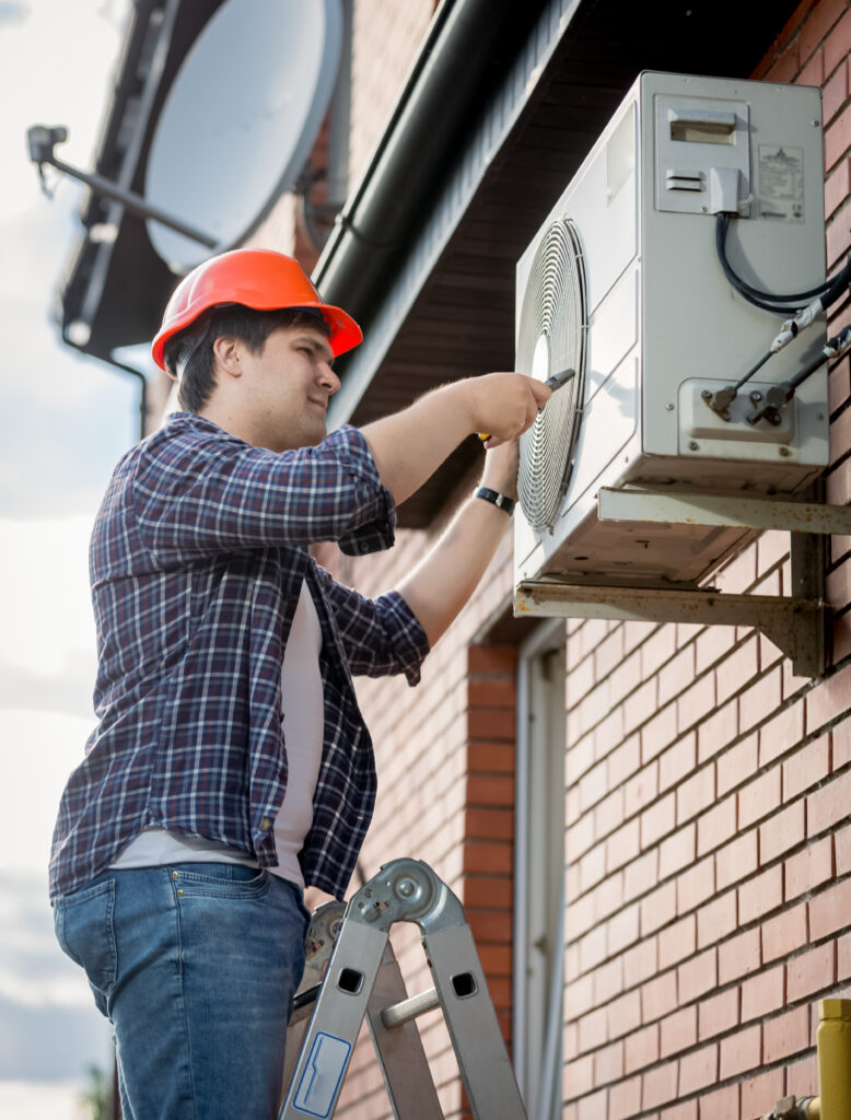 Male technician repairing outdoor air conditioning system | Buckeye Comfort Solutions